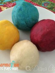 Multi coloured playdough balls on a plate