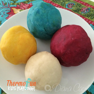 Multi coloured playdough balls on a plate