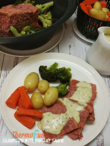 Silverside with parsley sauce on a plate with vegetables